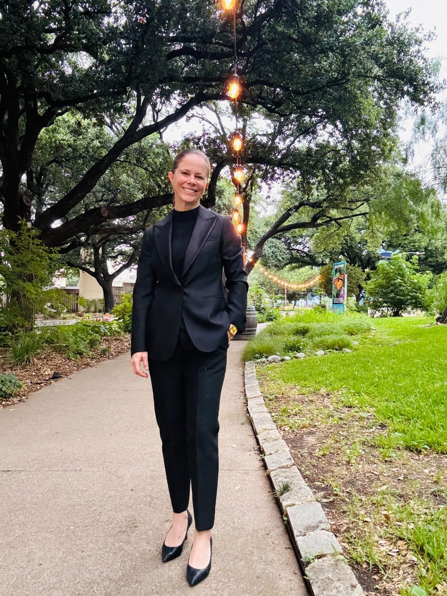 Chelsie walking outdoors in formal attire before a ceremony